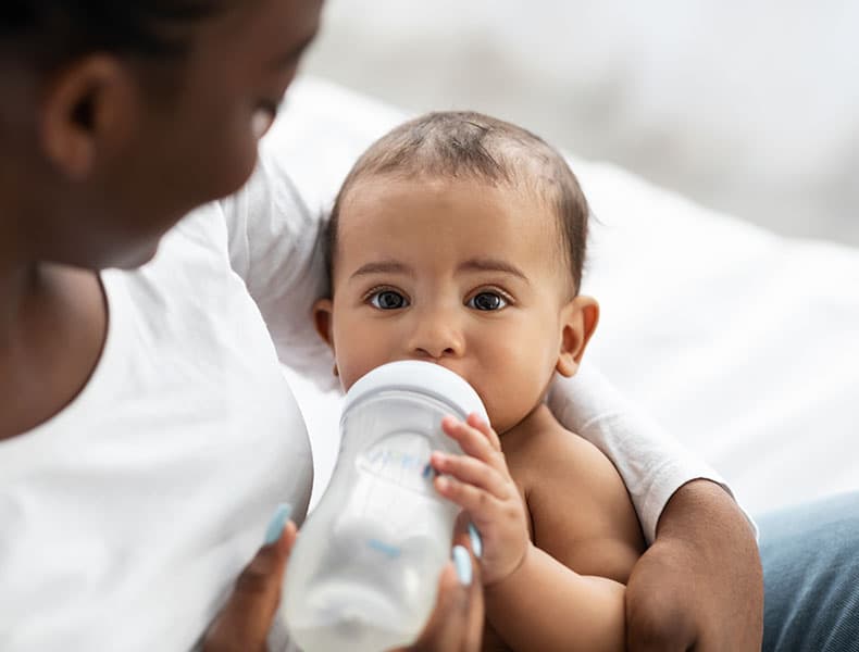 A caregiver cradling a smiling infant